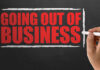 Retail Bloodbath: Giant Store Chain Sinking A hand writing 'GOING OUT OF BUSINESS' on a chalkboard