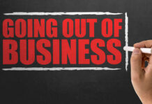 Retail Bloodbath: Giant Store Chain Sinking A hand writing 'GOING OUT OF BUSINESS' on a chalkboard