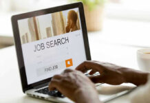 Vanishing Workers, Falling Rate — What Broke? Person searching for jobs on a laptop.