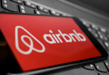 Airbnb logo on a phone screen, near keyboard.