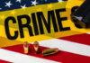5 Gunned Down: Targeted Massacre Stuns U.S. A gun and bullets on an American flag with a crime scene marker