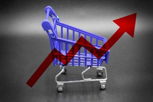 Isolated,Cart,With,A,Red,Graph,Arrow,Concept,Of,Rising A miniature shopping cart with a rising arrow in the background