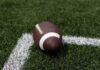 VIDEO: Shocking Romo Stop Caught On Video A brown football resting on green artificial turf near a white line