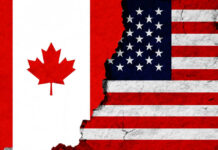 Canadian and American flags with torn dividing line