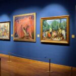 Museum Alarms Fail — Again! Art gallery showcasing various colorful paintings on a blue wall