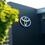 Toyota’s $3.6B U.S. Power Play Robotic arms welding car bodies in an automotive factory.