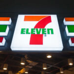 Corner-Store Massacre: 7‑Eleven Vanishes Exterior view of a 7-Eleven convenience store with All Cafe signage
