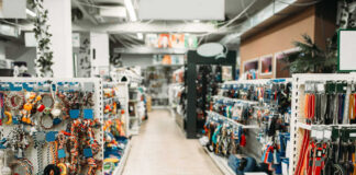 Pet store aisle with shelves of dog toys, leashes, and collars