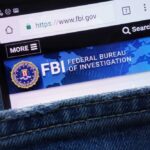 FBI Dangles Cash: Who Talks First? Mobile phone displaying the FBI website in a denim pocket