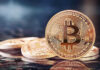 Bitcoin Whiplash Hammers Trump Media Bitcoin coins on a reflective surface.