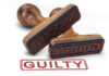 Two rubber stamps labeled guilty and innocent on a white surface