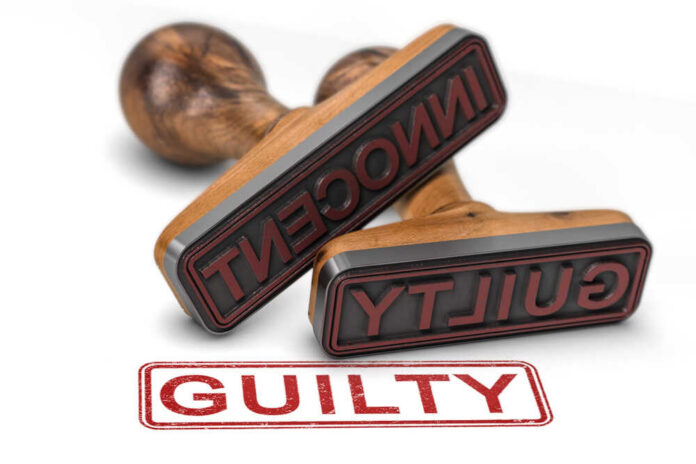 Two,Rubber,Stamps,Over,White,Background,With,The,Words,Innocent Two rubber stamps labeled guilty and innocent on a white surface
