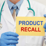 Metal In Dinner? Massive Recall Follows Doctor holding a product recall sign in gloves