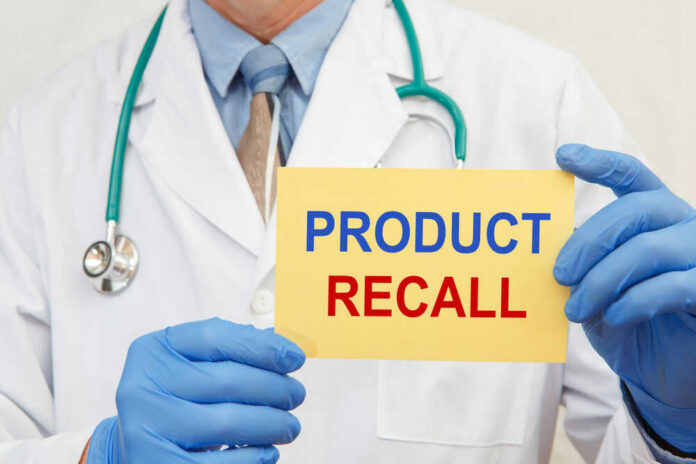 shutterstock_1849024102 Doctor holding a product recall sign in gloves