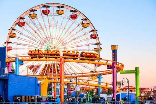 Santa,Monica,,Usa,-,December,27,,2015:,Ferris,Wheel,And Colorful amusement park scene featuring a ferris wheel and roller coaster at sunset