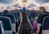 Airlines Tax The Overhead Now Airplane interior with passengers seated mid-flight.