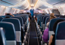 Airlines Tax The Overhead Now Airplane interior with passengers seated mid-flight.