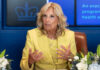 Woman in yellow suit speaking with hand gestures.