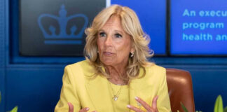 Woman in yellow suit speaking with hand gestures.