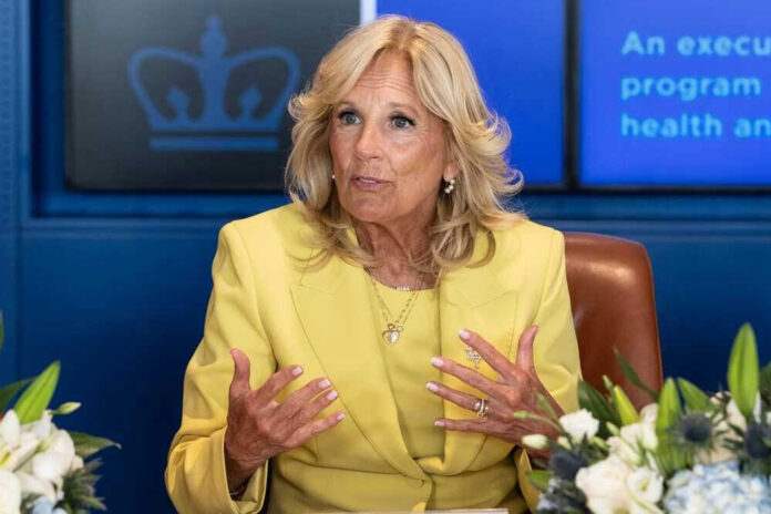 Woman in yellow suit speaking with hand gestures.