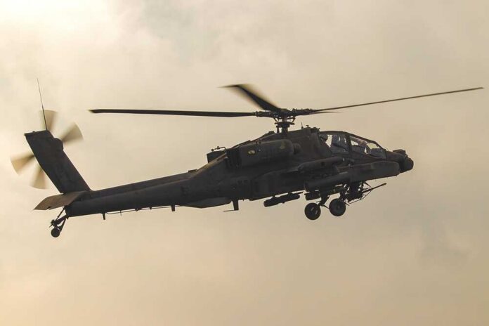 Hechtel-eksel,09-11-2022,Ah,64,Apache,In,Flight,At,Sanicole,International Military Apache helicopter flying against a blue sky