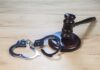 Gavel and handcuffs on wooden table