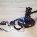 WWII Memorial Defaced — Felony Hammer Drops Gavel and handcuffs on wooden table