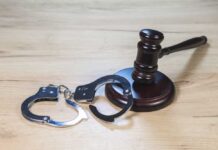 WWII Memorial Defaced — Felony Hammer Drops Gavel and handcuffs on wooden table