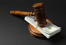 Judge’s gavel resting on a stack of US hundred-dollar bills