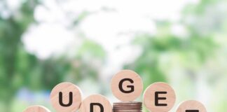 Stacks of coins with wooden discs spelling budget