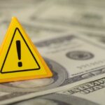 $89M Vanishes — No Wallets Touched A yellow warning sign placed on a pile of dollar bills