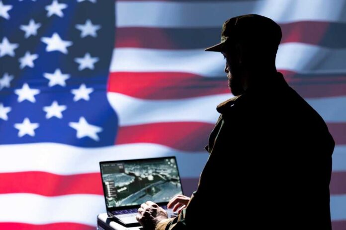 Us,Air,Force,Agent,Using,Radar,System,On,Laptop,To Silhouette of a person using a laptop before a large US flag