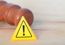 Judges Clash Over $20B Green War Yellow warning triangle with exclamation mark beside a wooden gavel