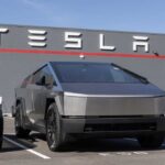 Tesla Cybertruck parked in front of a Tesla dealership