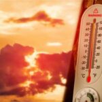 Record Heat Shocks U.S. — Nights Wouldn’t Cool Thermometer displaying high temperature against a sunset background