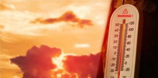 Thermometer displaying high temperature against a sunset background