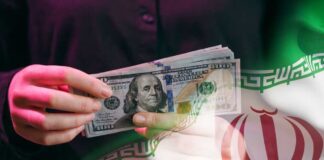 A person holding a stack of US hundred-dollar bills in front of the Iranian flag