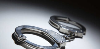 Close-up of metallic handcuffs on a light surface