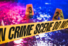 Buried Alive? Influencer Found in Suitcase Crime scene tape with blurred evidence markers.