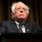Bernie’s War Chest Moves Revealed Bernie Sanders at a podium in a suit and tie