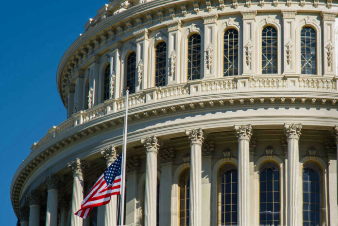 shutterstock_1547457971 U.S. Capitol dome with American flag.