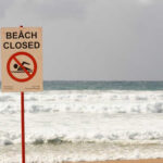 Rabid Beaver Attack Hits Popular Lake Sign indicating the beach is closed with a no swimming symbol