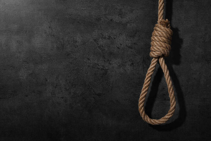 A noose made of rope hanging against a dark textured background