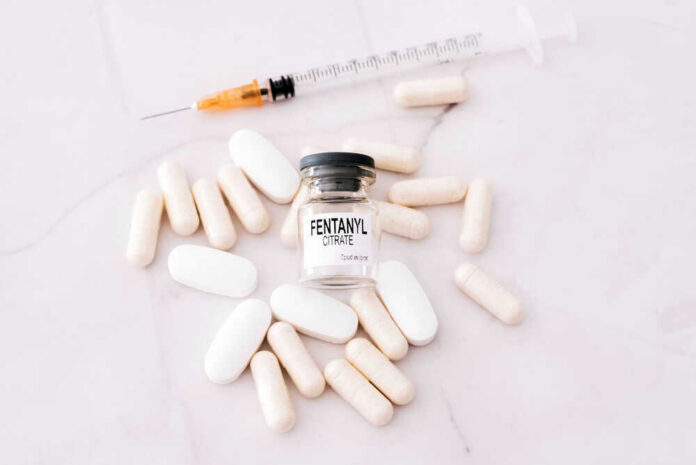 shutterstock_2020210628 Fentanyl citrate vial surrounded by various pills and syringe.