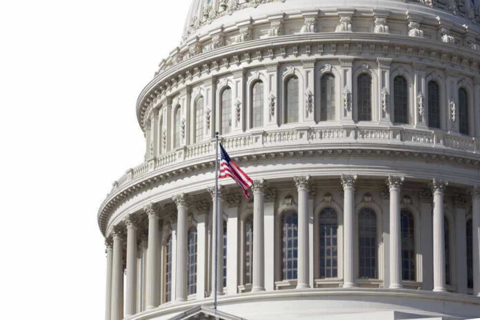 shutterstock_2082475843 U.S. Capitol dome with American flag flying.