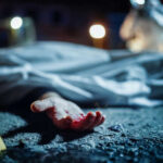 Downtown Bloodbath — No Arrests, No Answers Crime scene with covered body and hand exposed.