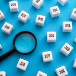 Six-Figure Jobs Sit Empty – Warning Issued Magnifying glass among cubes labeled job on blue background