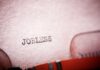 Famed Carmaker Axes Thousands Close-up of a typewriter with the word 'JOBLESS' typed on paper