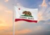 California state flag waving against a sunset sky