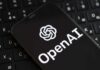 Smartphone displaying OpenAI logo on a keyboard